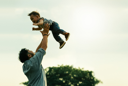 Father's day. Happy joyful father having fun throws up in the air child.の写真素材