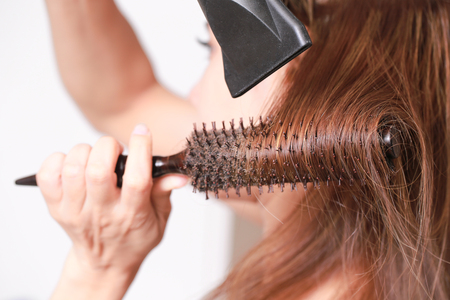 Making hairstyle using hair dryer yourself.の写真素材
