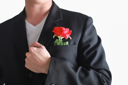 Business man having a red rose isolated on white background. valentine conceptの写真素材