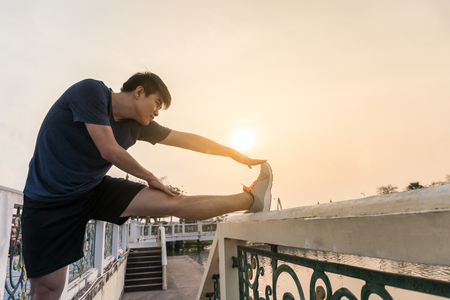 Young man asian stretching a leg in the park.の写真素材