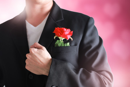 Business man having a red rose on pink valentine concept.の写真素材