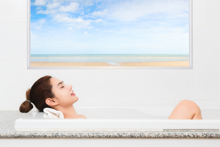 Just relax. Content beautiful young woman relaxing while taking a bath.の写真素材