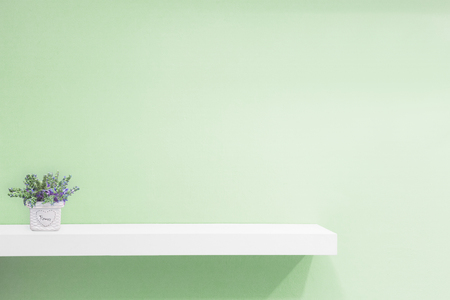 Empty white shop shelf, retail shelf on green vintage background.の写真素材