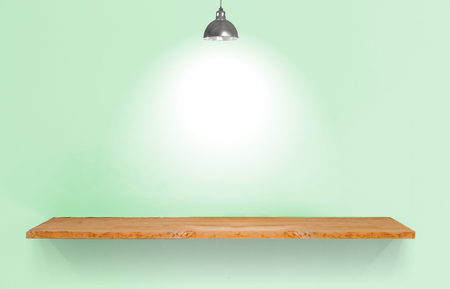 Wooden shelf with lamp on green vintage wall.の写真素材
