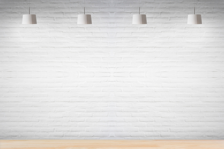 White brick wall in room with wooden floor with lamps.の写真素材