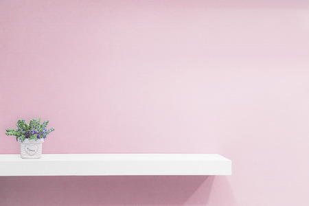 Empty white shop shelf, retail shelf on pink vintage background.の写真素材
