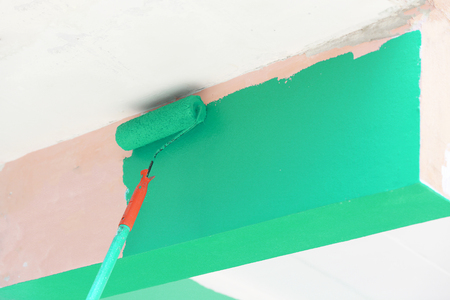 Close-up paint roller on wall with in new house.の写真素材