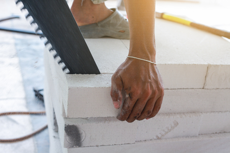 Worker cutting bricks with crosscut saw.の写真素材