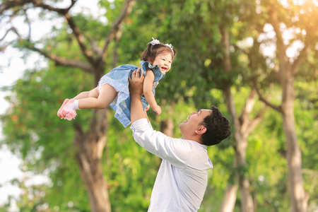 Father's day. Happy joyful father having fun throws up in the air child.の写真素材