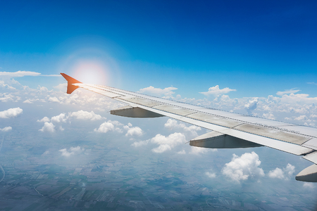 Wing of the plane on blue sky with sunlight. travel conceptの写真素材