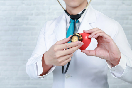 Doctor holding red heart with electrocardiogram. Cardiology concept.の写真素材