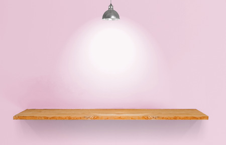 Wooden shelf with lamp on pink vintage wall.の写真素材