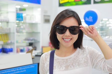 Young woman in sunglasses looking at camera in shop.の写真素材