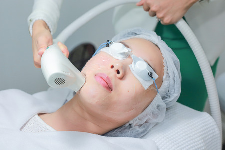 Beautician Giving Laser Epilation Treatment To Young Woman Face.の写真素材