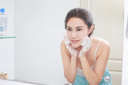 Asian woman cleaning face skin enjoy herself with bubble cleansing foam.の写真素材