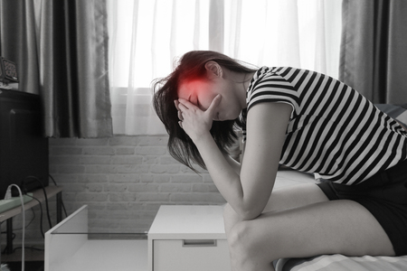 Young woman having a headache on bed.の写真素材