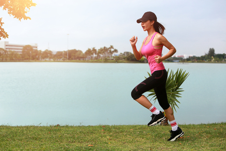 Sporty female jogger morning exercise on seaside on grass. vintage toneの写真素材