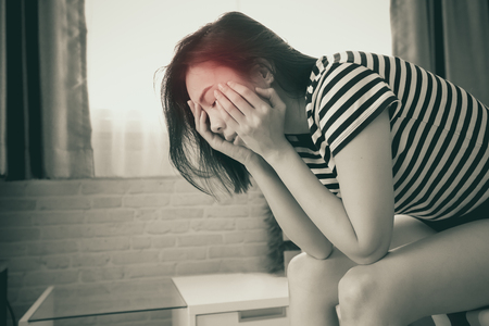 Young woman having a headache on bed.の写真素材
