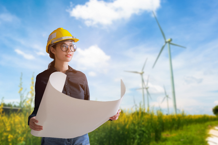 Woman engineer looking the wind turbines on background.の写真素材