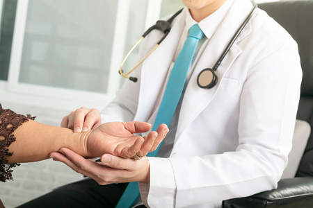 Doctor is holding hand at the patient's heart rate.の写真素材