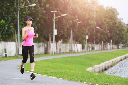 Sporty female jogger morning exercise on seaside in the park.の写真素材