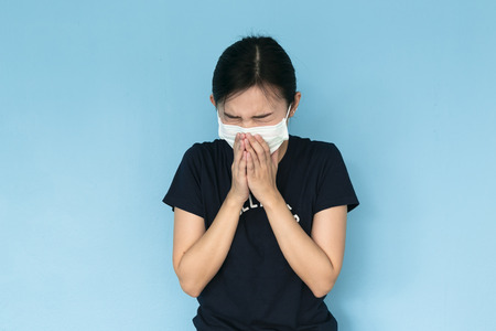 Woman suffer from sick on blue background.の写真素材