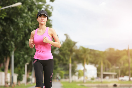 Sporty female jogger morning exercise in the park.の写真素材