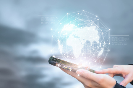 Businessman holding phone in hand with global connection concept.の写真素材