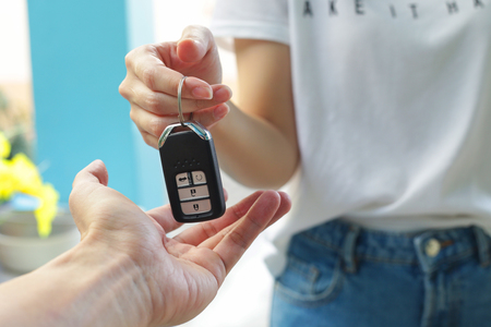 Hand of business woman gives the car key.の写真素材