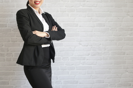 Pretty girl in black suit standing and smiling in her office. body partの写真素材
