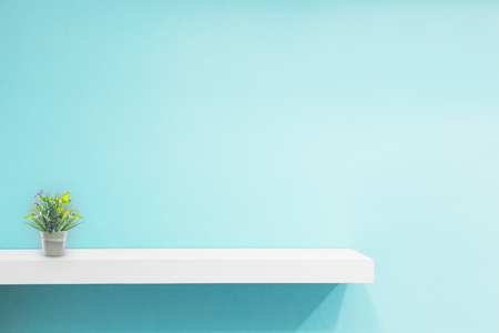 Empty white shop shelf, retail shelf on blue vintage background.の写真素材