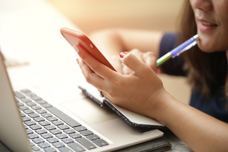 Woman sitting at desk and working at computer close up in hands.の写真素材