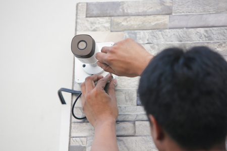 Technician installing CCTV camera for security service.の写真素材