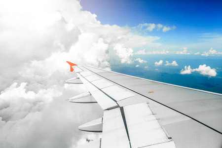Wing of an airplane flying above in the morning clouds.の写真素材