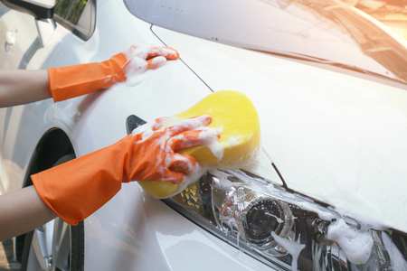 Woman holds the microfiber in hand and polishes the car.の写真素材