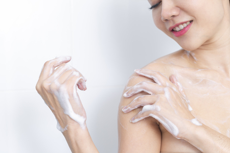 Woman taking a shower enjoying water splashing on her.の写真素材