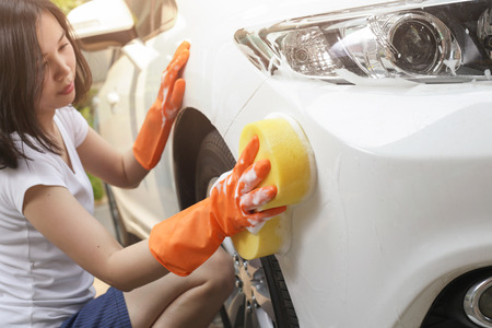 Woman holds the microfiber in hand and polishes the car.の写真素材