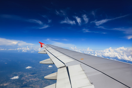 Wing of an airplane flying above in the morning clouds.の写真素材