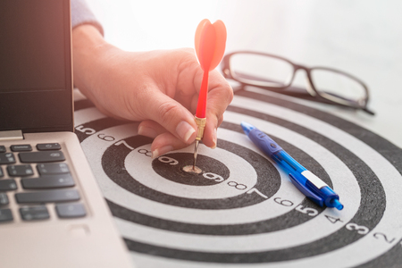 Businesswoman hands holding a darts aiming the target  business goal concept.の写真素材