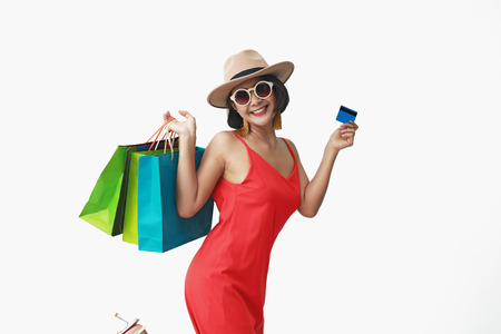 Portrait of beautiful girl wearing dress and sunglasses holding shopping bags.の写真素材