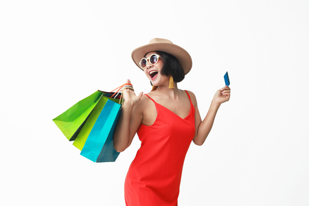 Portrait of beautiful girl wearing dress and sunglasses holding shopping bags.の写真素材