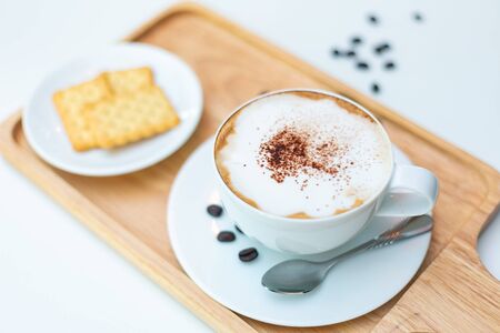 Hot coffee on background served with cream crackers on white plate.の写真素材