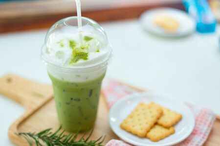 Iced Green tea with cracker on wooden plate.の写真素材