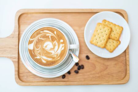 Hot coffee on background served with crackers on white plate. on topの写真素材