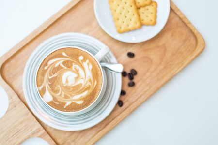 Hot coffee on background served with crackers on white plate. on topの写真素材