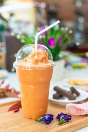 Milk tea or Thai milk tea on the wooden plate.の写真素材