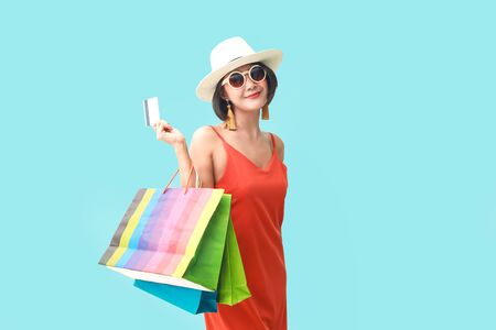 Portrait of asian girl wearing dress and sunglasses holding shopping bags.の写真素材
