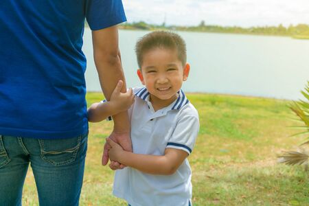 Father and son holding hand in hand happy smiling in the park.の写真素材