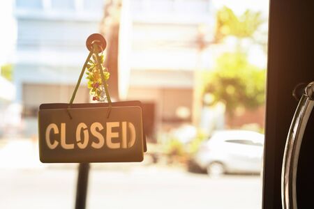 Closed sign hanging front of cafe with colorful bokeh light background. Business serviceの写真素材