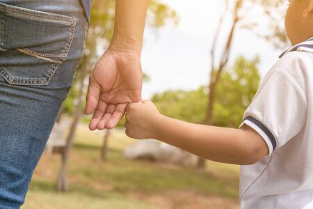 Father and son holding hand in hand happy smiling in the park.の写真素材